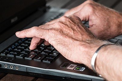 elderly hands on laptop